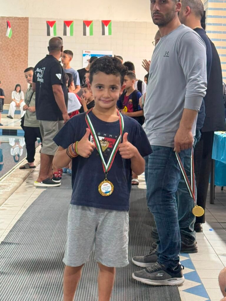 Young swimmer smiling with a championship medal.